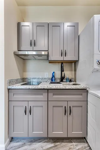 a kitchen with granite countertop a sink and cabinets