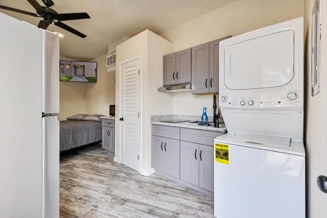 a kitchen with stainless steel appliances a refrigerator sink and white cabinets