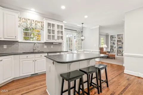 a kitchen with granite countertop white cabinets and white appliances