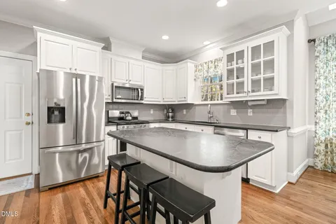 a kitchen with stainless steel appliances granite countertop a sink a stove and cabinets