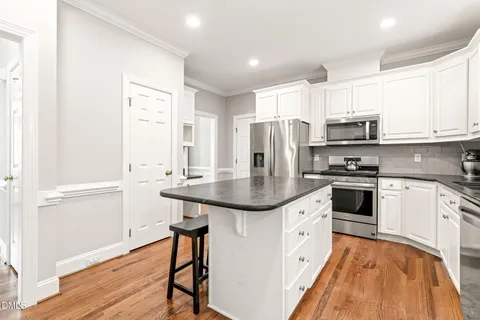 a kitchen with white cabinets and sink