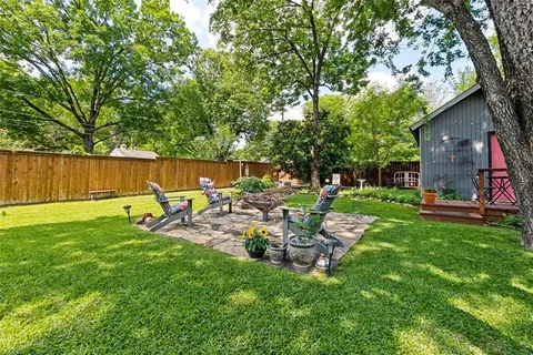 a view of a chair and table in backyard of the house