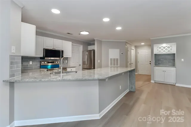 a large kitchen with granite countertop a large counter top appliances and cabinets