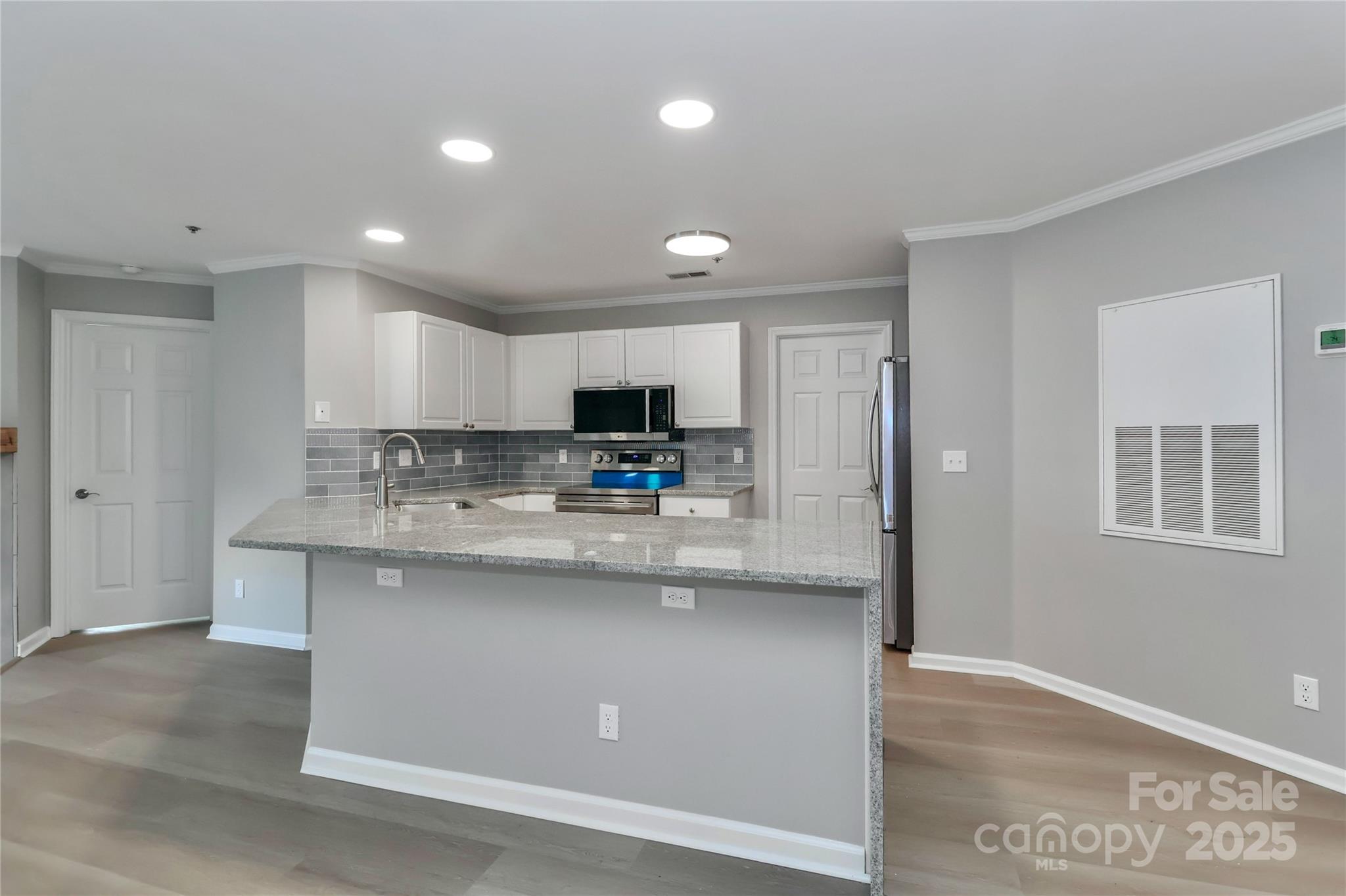 18563 Vineyard Point Lane Cornelius, NC 28031 - Photo 9 of 23 a kitchen with stainless steel appliances granite countertop a sink a stove and a refrigerator