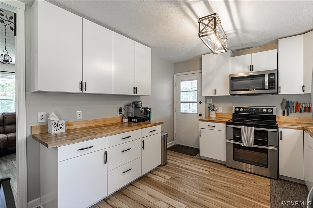 6039 Old Nottoway Road Crewe, VA 23930 - Photo 12 of 46 a kitchen with stainless steel appliances white cabinets a sink and a stove