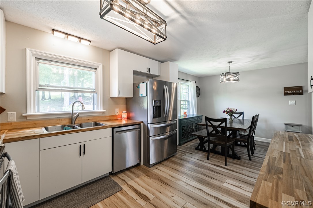 6039 Old Nottoway Road Crewe, VA 23930 - Photo 15 of 46 a kitchen with stainless steel appliances granite countertop a sink dishwasher a microwave oven and a dining table with wooden floor