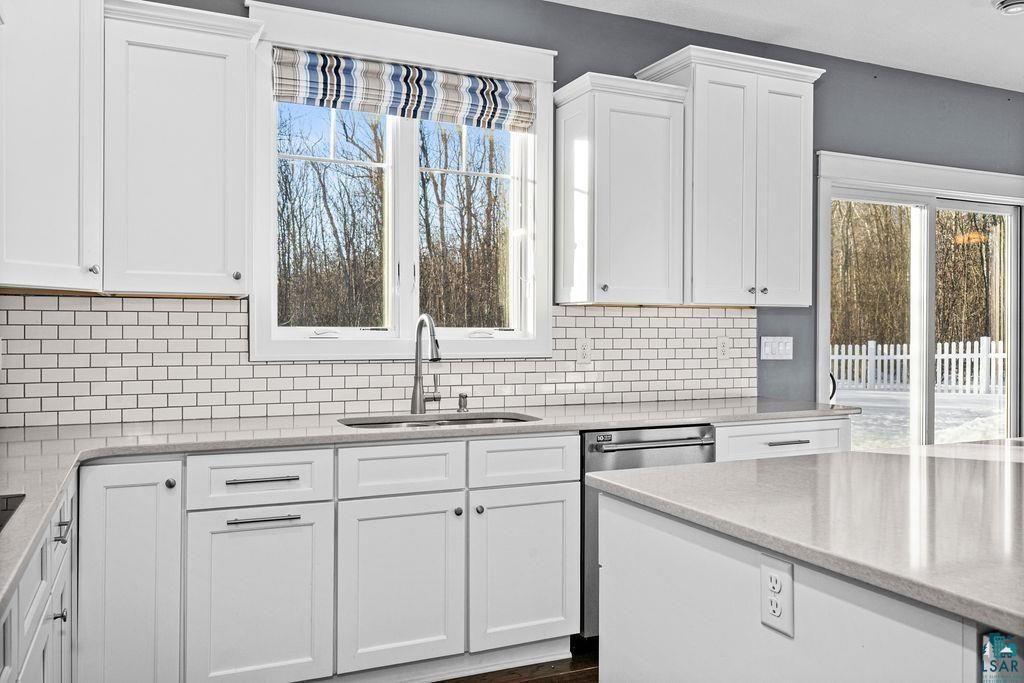 3879 Okerstrom Road Hermantown, MN 55811 - Photo 9 of 32 Kitchen with white cabinets, light stone counters, and dishwasher
