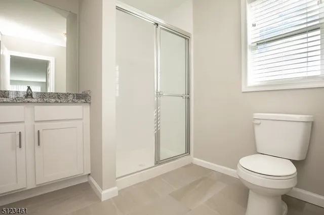 a bathroom with a granite countertop toilet a sink and a mirror