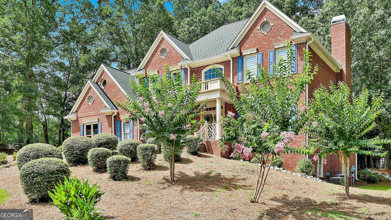 a front view of a house with a yard and potted plants