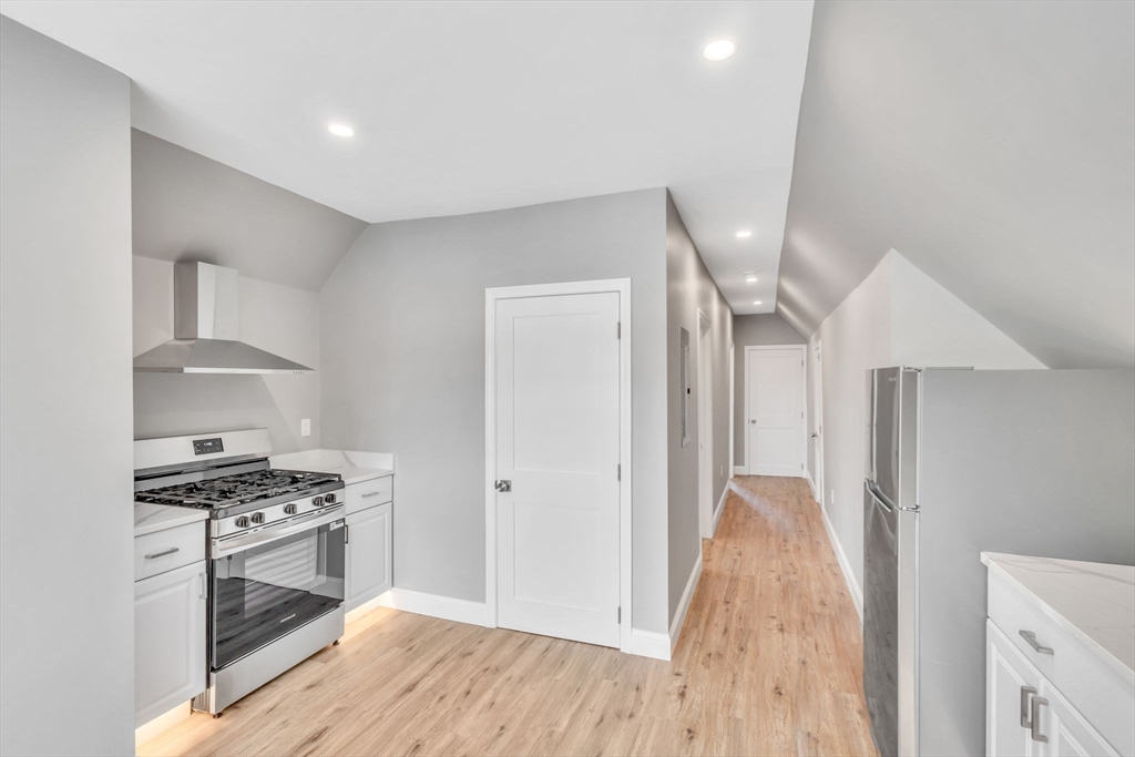 5 Beckford Street, Unit 3 Beverly, MA 01915 - Photo 5 of 15 a kitchen with granite countertop a stove and a refrigerator