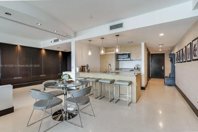 a dining hall with stainless steel appliances a dining table and chairs