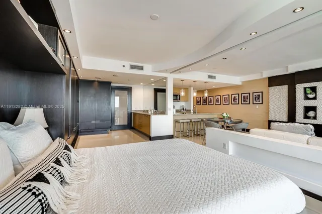 a large bedroom with a large bed and wooden floor