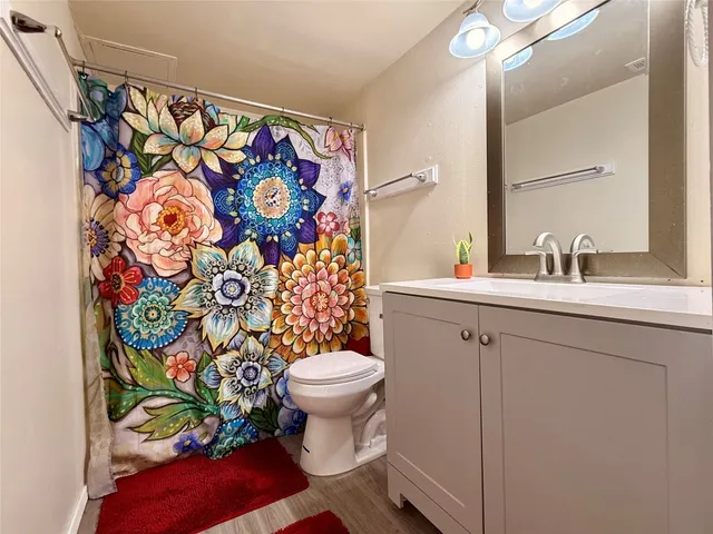 a bathroom with a toilet sink and shower curtain