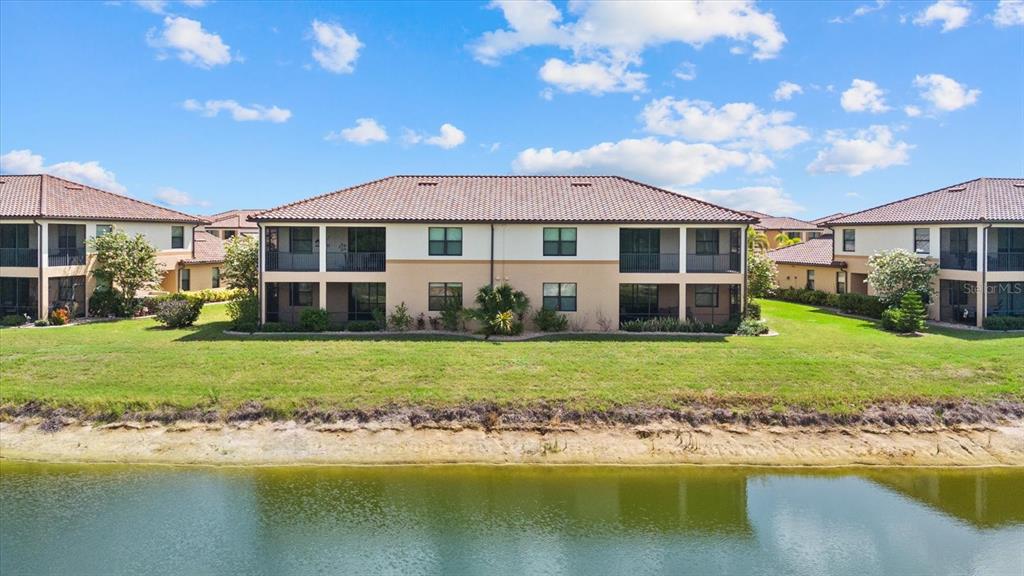 20080 Ragazza Circle, Unit 102 Venice, FL 34293 - Photo 10 of 49 a front view of a house with a garden