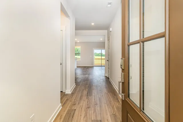 an empty room with wooden floor fireplace and windows