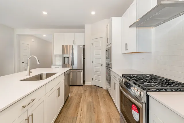 a kitchen with stainless steel appliances a refrigerator stove microwave and cabinets