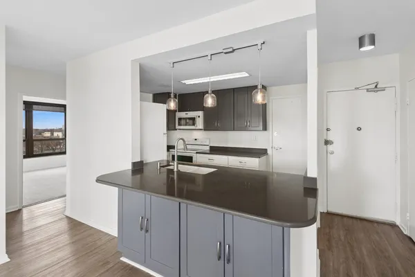 a kitchen with stainless steel appliances granite countertop a sink and a refrigerator
