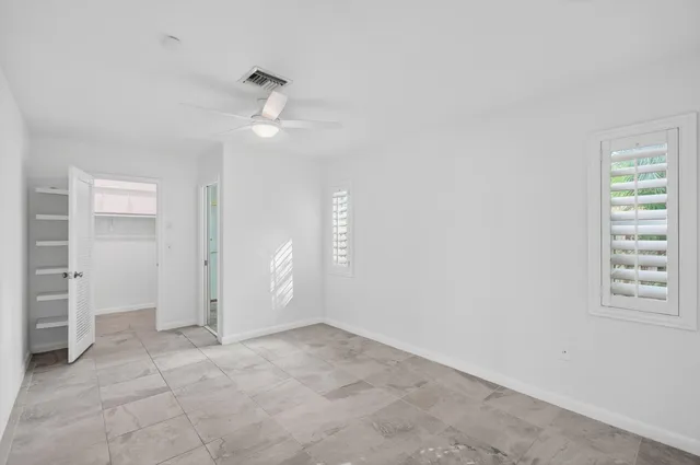 a view of a room with a ceiling fan and a window