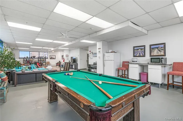 a room with pool table and windows