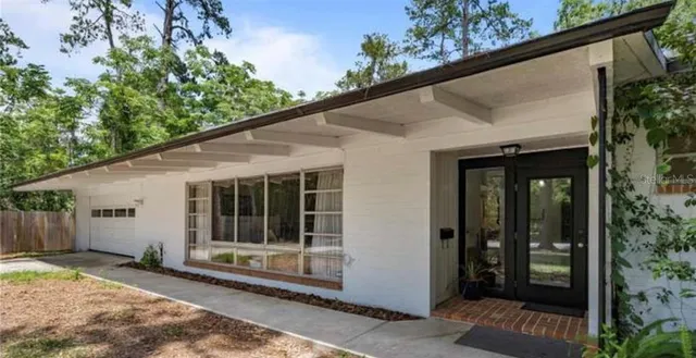 a view of backyard with large window and wooden fence
