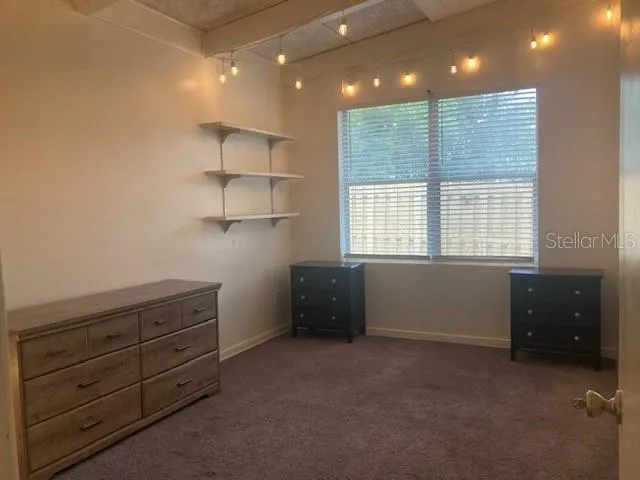 a spacious bedroom with a bed and a mirror