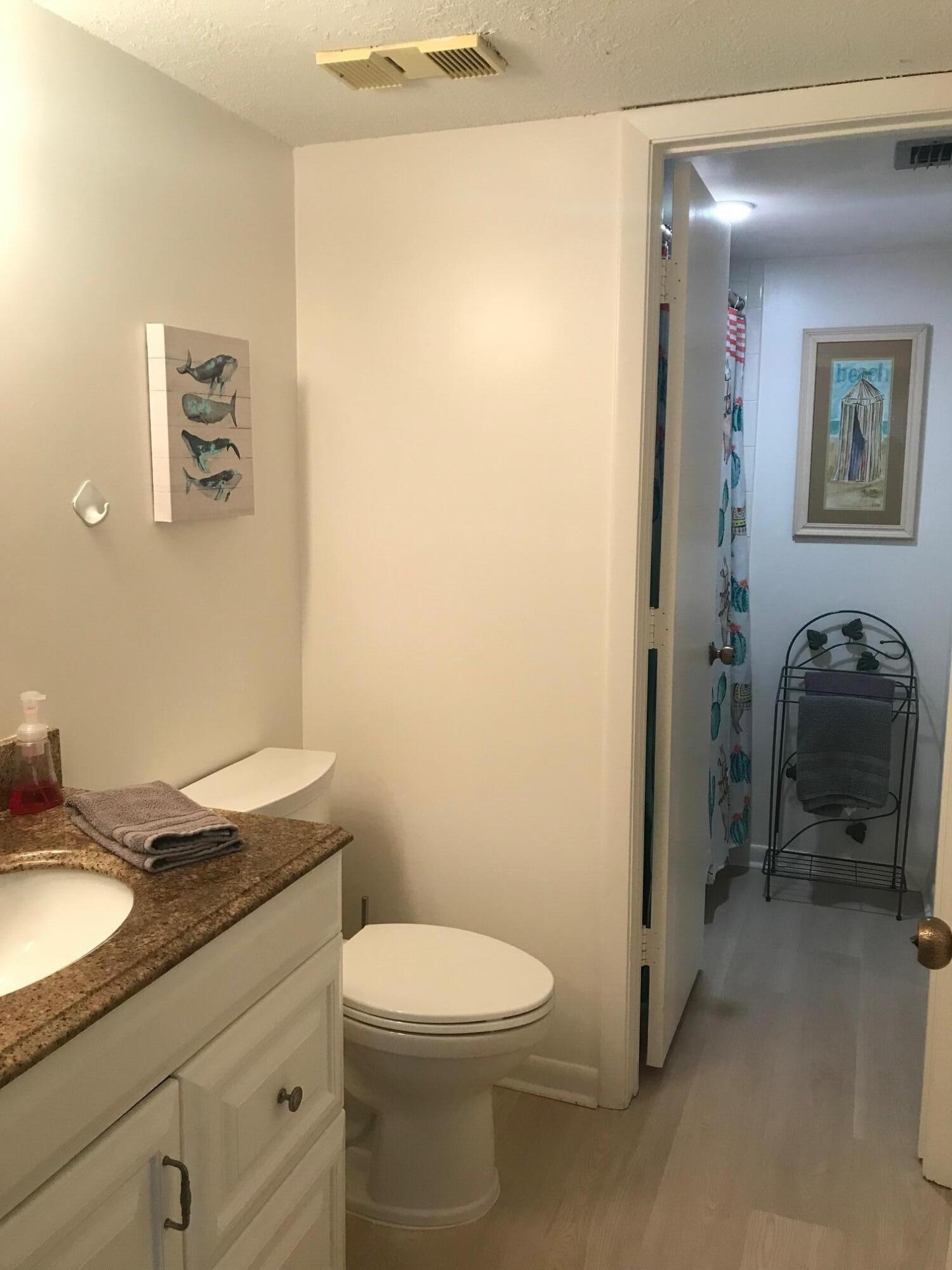 353 Highway 1, Unit D203 Jupiter, FL 33477 - Photo 11 of 13 a bathroom with a granite countertop sink mirror vanity and toilet