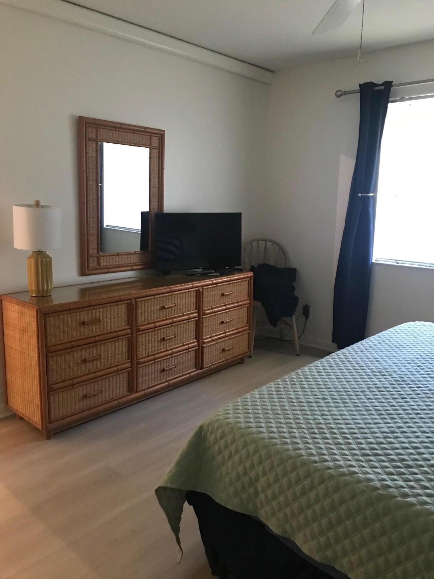 353 Highway 1, Unit D203 Jupiter, FL 33477 - Photo 12 of 13 a bedroom with a bed and a mirror on dresser