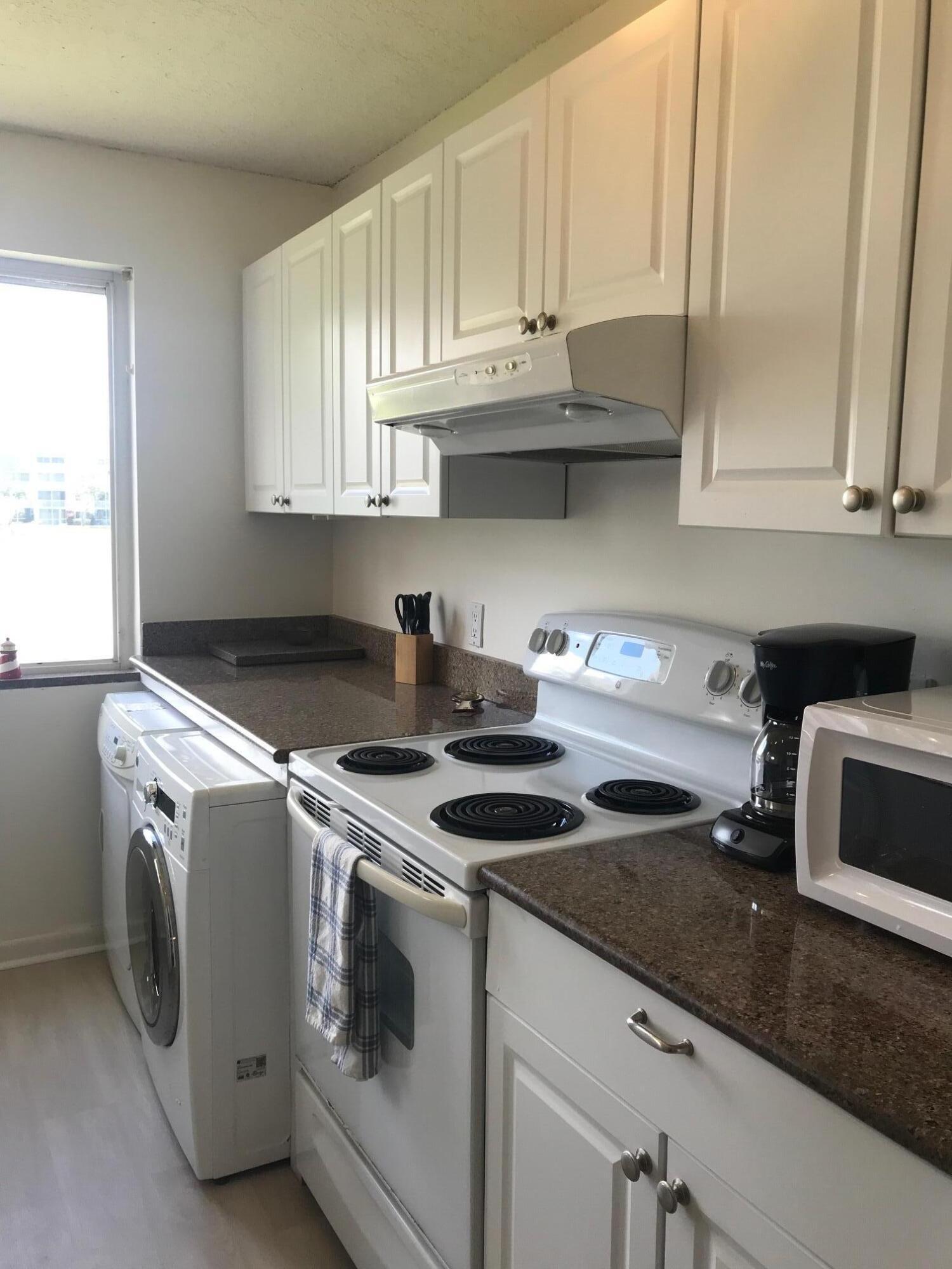 353 Highway 1, Unit D203 Jupiter, FL 33477 - Photo 5 of 13 a kitchen with granite countertop a sink a stove and cabinets