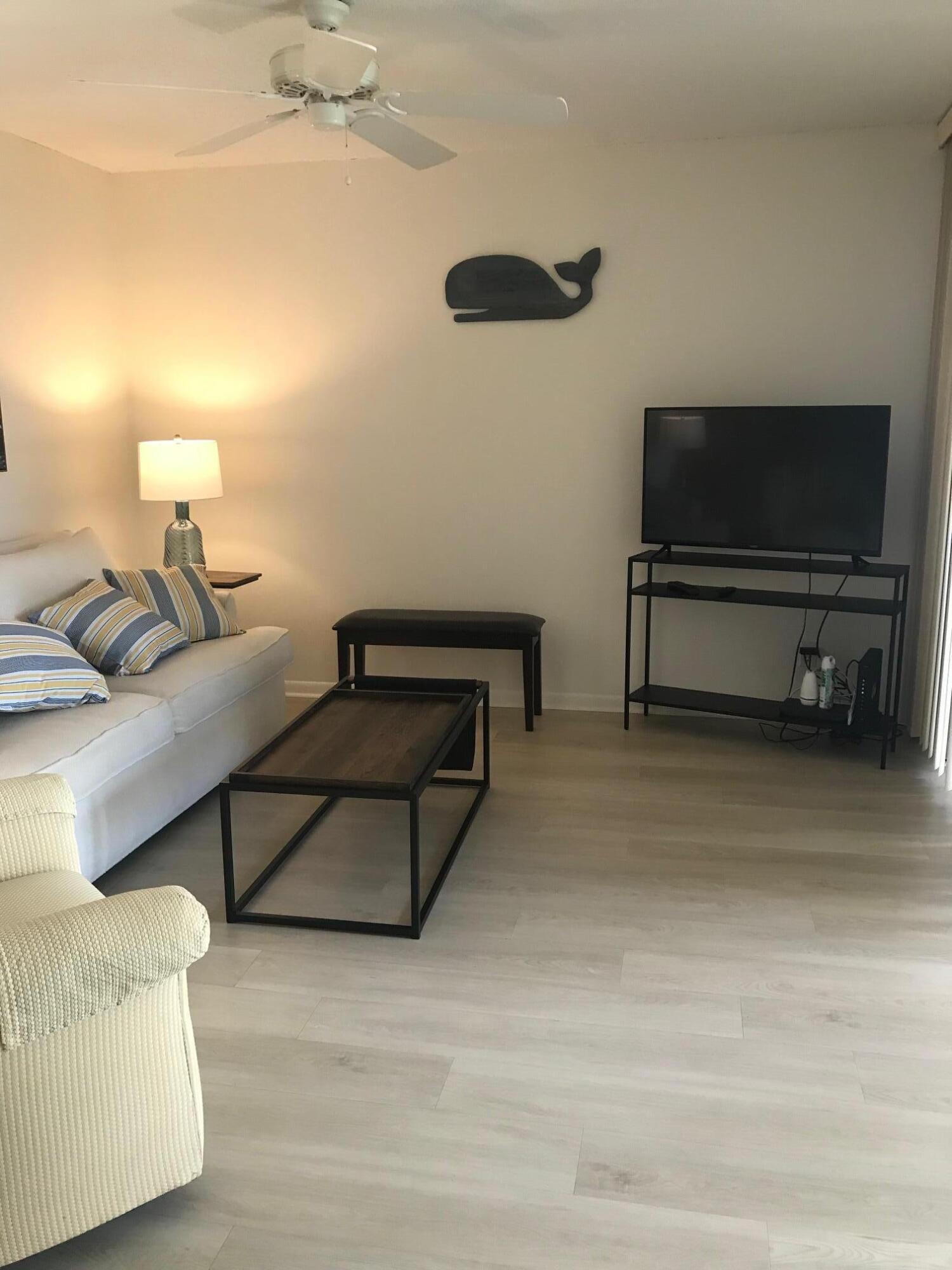 353 Highway 1, Unit D203 Jupiter, FL 33477 - Photo 8 of 13 a living room with furniture and a flat screen tv