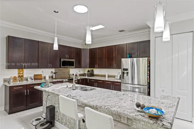 a kitchen with kitchen island a sink stove and refrigerator