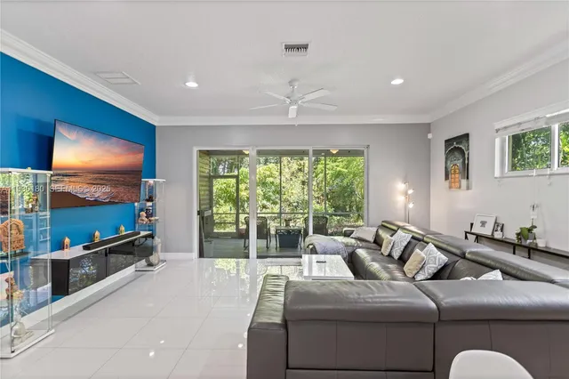 a living room with furniture a large window and a flat screen tv