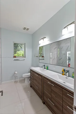 a bathroom with a double vanity sink and a mirror