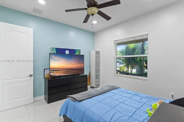 a bedroom with a bed and a flat screen tv