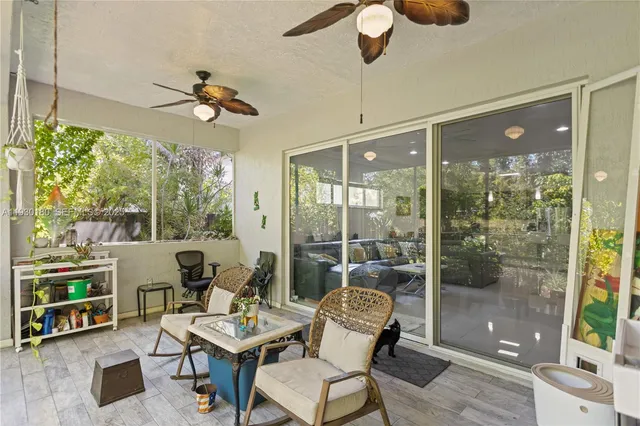 a porch with a table and chairs and potted plants