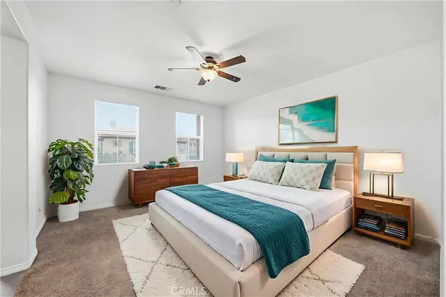 a spacious bedroom with a bed and a chandelier