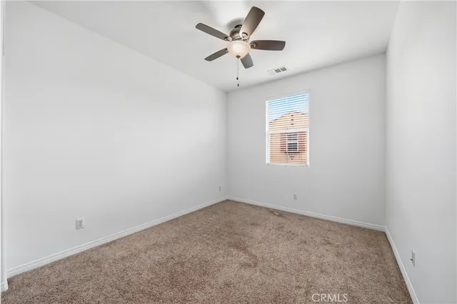 an empty room with a window and a ceiling fan