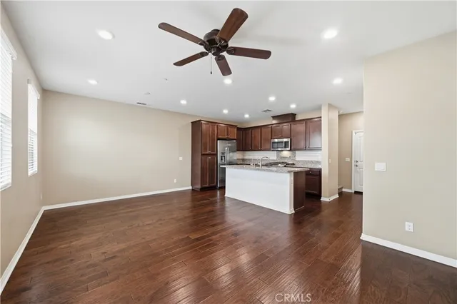 a open kitchen with kitchen island white cabinets and stainless steel appliances