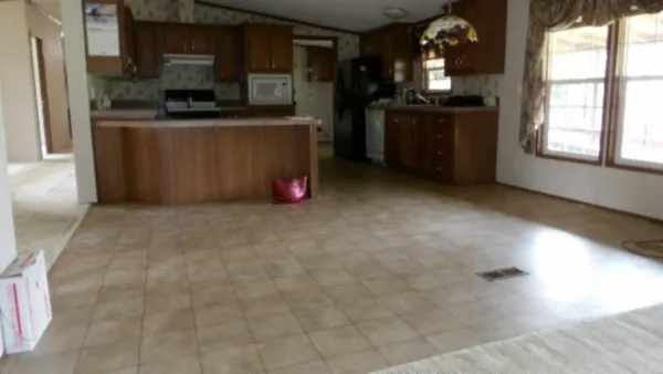 an empty room with windows and fireplace