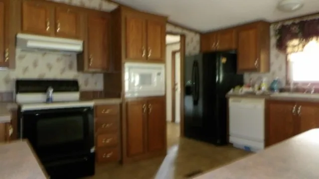a kitchen with stainless steel appliances wooden cabinets and a sink