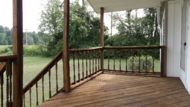a view of a balcony with wooden floor and fence