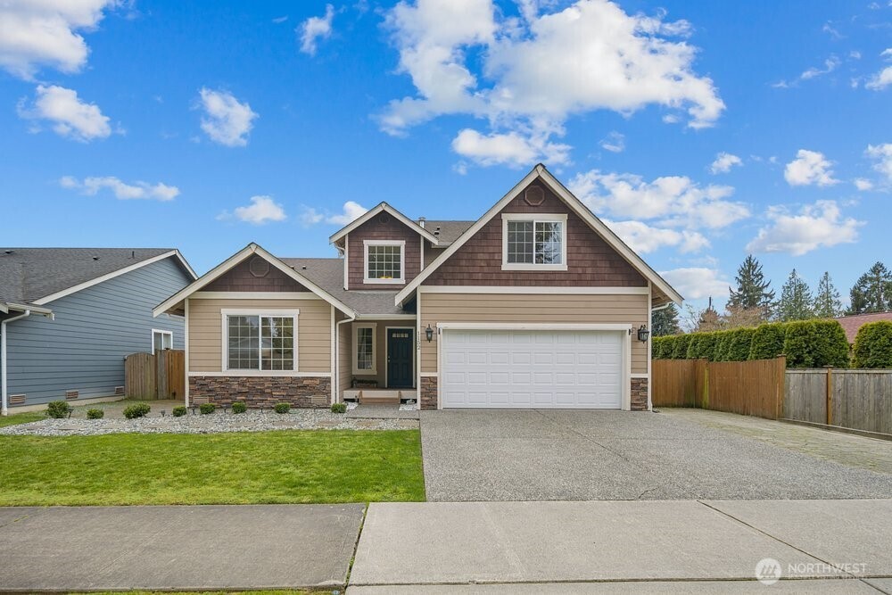 a front view of a house with a garden and garage