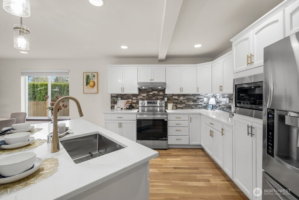 1152 Johnson Street Monroe, WA 98272 - Photo 21 of 38 a kitchen with white cabinets and appliances