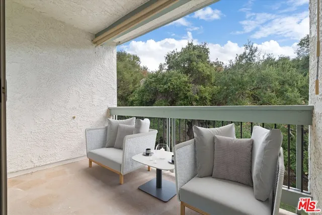 a balcony with wooden floor and outdoor seating