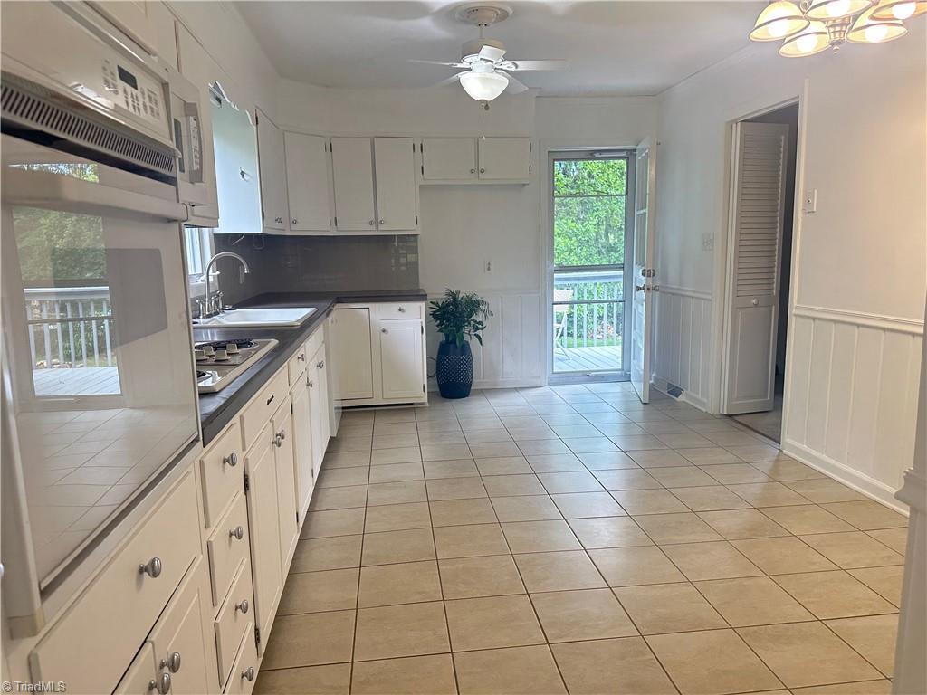 4261 Witherow Road Winston-Salem, NC 27106 - Photo 6 of 40 Large kitchen with eat in area and door to back deck. Doorway on the right leads to the den