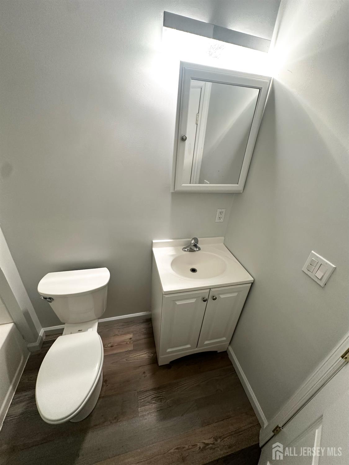 55 Cutters Dock Road, Unit B Woodbridge, NJ 07095 - Photo 12 of 13 a bathroom with a toilet sink and mirror