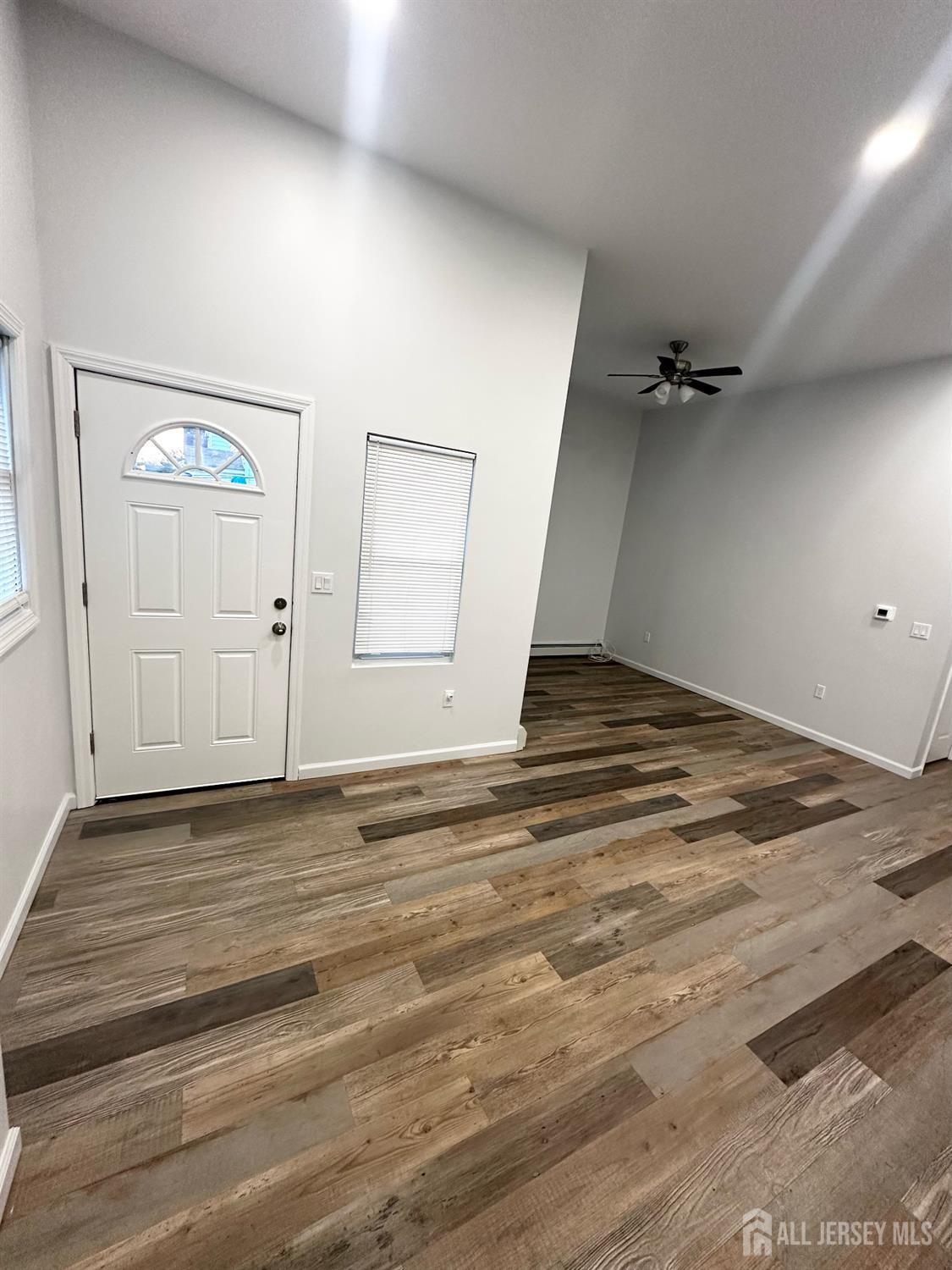 55 Cutters Dock Road, Unit B Woodbridge, NJ 07095 - Photo 3 of 13 an empty room with wooden floor and mirror