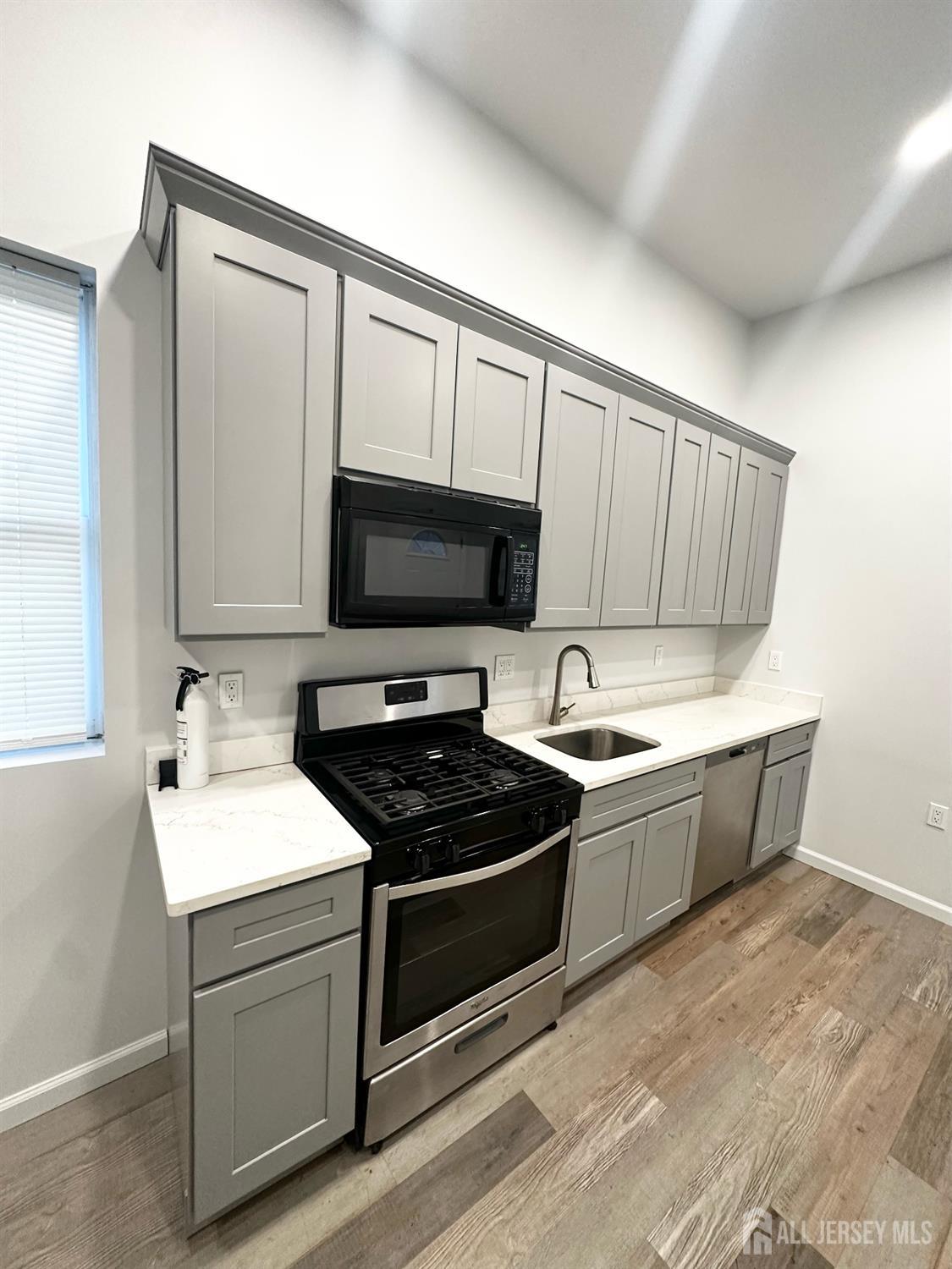 55 Cutters Dock Road, Unit B Woodbridge, NJ 07095 - Photo 5 of 13 a kitchen with a sink stove and microwave