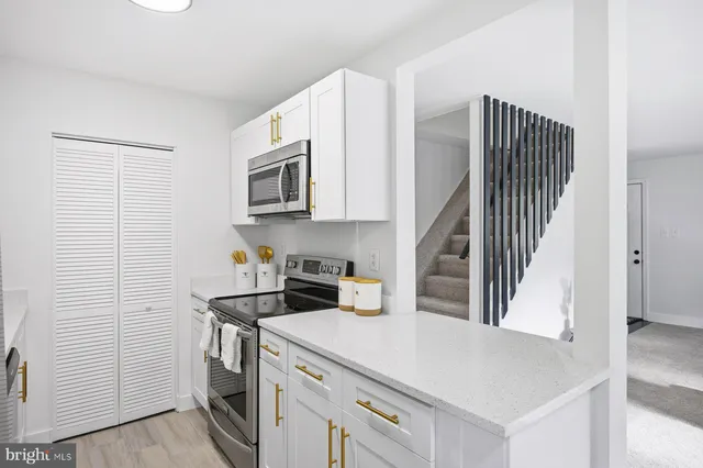 a kitchen with a refrigerator and a stove top oven