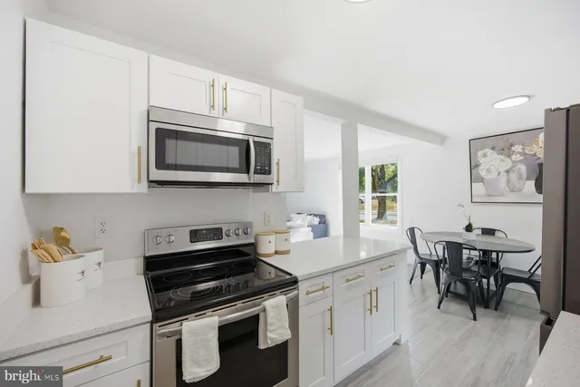 a kitchen with stainless steel appliances a white cabinets and stove top oven