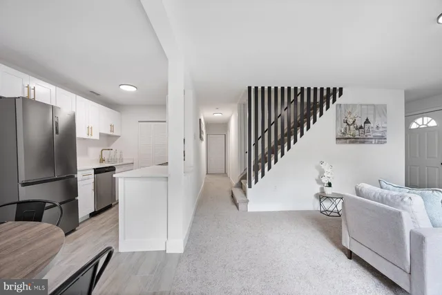 a view of a kitchen with refrigerator and white cabinets